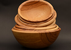 Stack of ash salad bowls, featuring beautiful grain patterns and warm, honey-brown heartwood.  Largest is 13" diameter, 5½" height turned by Dennis Curtis.